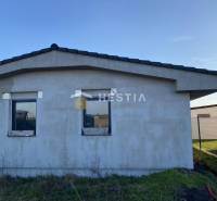 Családi ház Székelyeken befejezetlen homlokzattal, lapos tető, két ablak.