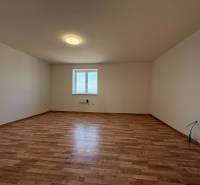 Tágas szoba ablakkal és fa dekorációjú padlóval egy családi házban.