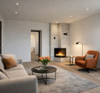 Nappali kandallóval, kényelmes ülőgarnitúrával és fa dekorációjú padlóval egy családi házban.