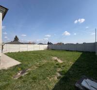 Családi ház kertje Nemesócsán, kerítéssel körülvéve, füves felület.