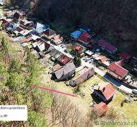 Kilátás a Moštenicában található házakra, amelyek az erdőben és a környező természetben helyezkednek el.