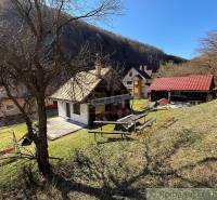 Házikó Moštenicában, természet és fák által körülvéve a lejtőn.