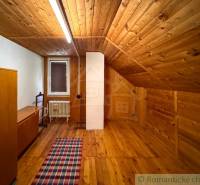 Egy fahatású padlóval és paraszti bútorokkal berendezett házikó belső tere.