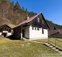 Házikó Moštenicában, természet és erdő ölelésében, tiszta égbolttal és füves területtel.
