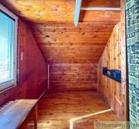 Egy fahatású padlóval és tetőablakkal rendelkező szoba a házikóban.