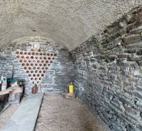 Kőpince a szőlőskertben bor tárolóhellyel és edényeknek polccal.