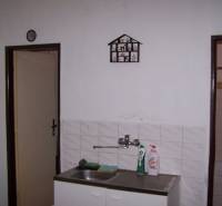 Konyha függő edényszárítóval a mosogató mellett egy kétszobás lakásban.