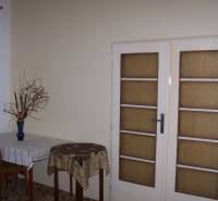 2 szobás lakás belső tere étkezőasztallal és üvegajtókkal.