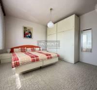 Hálószoba családi házban nagy szekrénnyel, ággyal és képpel a falon.