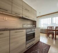 Konyha egy családi házban fa dekorációjú padlóval és étkezőasztallal.