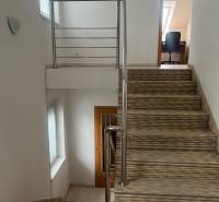 Lépcső korláttal vezet a szobába a családi házban, fehér falak.