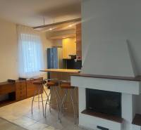 Konyha családi házban bárral, kandallóval, fa dekorációval és bútorokkal.