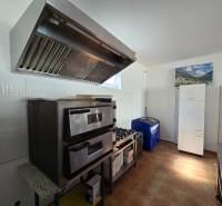 Vendéglátó helyiségek sütővel, páraelszívóval és hűtőszekrénnyel, fa dekorációjú padlóval.