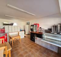 Vendéglátóhely belső tér pulttal, hűtővitrinekkel és pizzásdobozokkal.