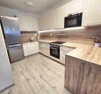 Konyha fa hatású padlóval egy 2 szobás lakásban, modern konyhabútorral.