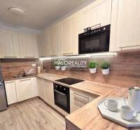 Modern konyha egy kétszobás lakásban fa dekorációval és beépített készülékekkel.