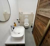 Fürdőszoba egy háromszobás lakásban tükörrel, mosdóval és modern dekorációval.