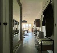 Előszoba nagy tükörrel, fogasokkal és paddal egy háromszobás lakásban.