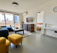 Háromszobás lakás nappalija kanapéval, televízióval és erkéllyel.