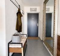 A háromszobás lakás előszobája padkával, fogassal és nagy tükörrel a falon.