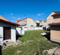 Kert a családi ház mögött a Hviezdoslav utcában, Pöstyénben, tetővel és kerítéssel.