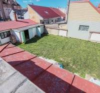 A Hviezdoslav utca-i családi ház udvara Pöstyénben, gyep és kocsibeállóval.