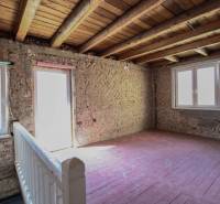 Családi ház belső tere csupasz téglafalakkal, fa mennyezettel és padlóval.