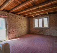 Családi ház belső tere téglafalakkal és nagy ablakokkal, fa dekorációjú padlóval.