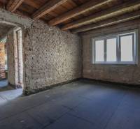 Családi ház felújítás alatt álló nyers téglafalai és mennyezete.