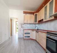 Konyha egy háromszobás lakásban, fa dekor padlóval és világos bútorokkal.