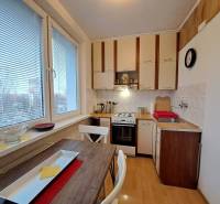 Konyha egy kétszobás lakásban gáz tűzhellyel és fa mintázatú padlóval.