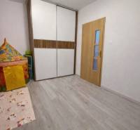 Gyerekszoba fa mintázatú padlóval és színes sátorral egy háromszobás lakásban.