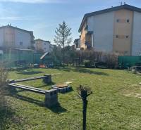 Füves terület padokkal és lakóházakkal az M.R.Štefánika utcában, Most pri Bratislave.