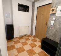 3 szobás lakás folyosója járólappal, fogassal és faajtókkal.