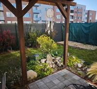 Kert a Jaseňová utcai kétszobás lakásnál Miloslavovban, pergolával és zölddel.