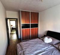 Spálňa v 3-izbovom byte s veľkou vstavanou skriňou a podlahou s dreveným dekorom.