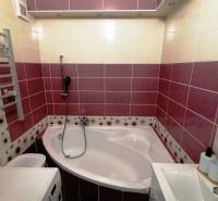 Kúpeľňa v 3-izbovom byte s rohovou vaňou a farebnými obkladmi.