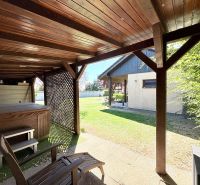 Fából készült pavilon pezsgőfürdővel a családi ház kertjében, a Močenská utcában, Cabaj-Čáporban.