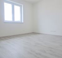 Üres szoba fehér falakkal és fa mintázatú padlóval egy családi házban.