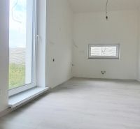 Családi ház belső tere fa dekorációjú padlóval és nagy ablakkal.