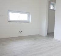 Szoba egy családi házban fa dekoros padlóval és kis ablakkal.