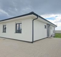 Családi ház Topoľnicán fehér homlokzattal és kövezett udvarral.