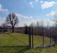 Telkek - lakóövezet Lubinában, kilátással a kerítésen keresztül az erdőre és a panorámára.