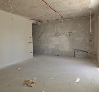 Befejezetlen szoba egy háromszobás lakásban, a mennyezetről lógó vezetékekkel.