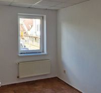 Fehér fal ablakkal, radiátorral és csempével egy családi házban.