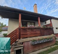 Családi ház Tureň községben, fa korláttal és virágdíszítéssel a verandán.