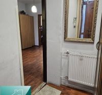 Családi ház belső tere fa dekorációjú padlóval, tükörrel és radiátorral.