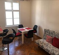 Étkező sarok egy kétszobás lakásban fa dekor padlóval és stílusos ülőgarnitúrával.