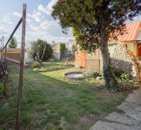 A Piešťany-i Mlynska utcai családi ház kertje gyepes és fákkal van beültetve.