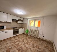 Családi ház konyhája csempével és fehér szekrényekkel.